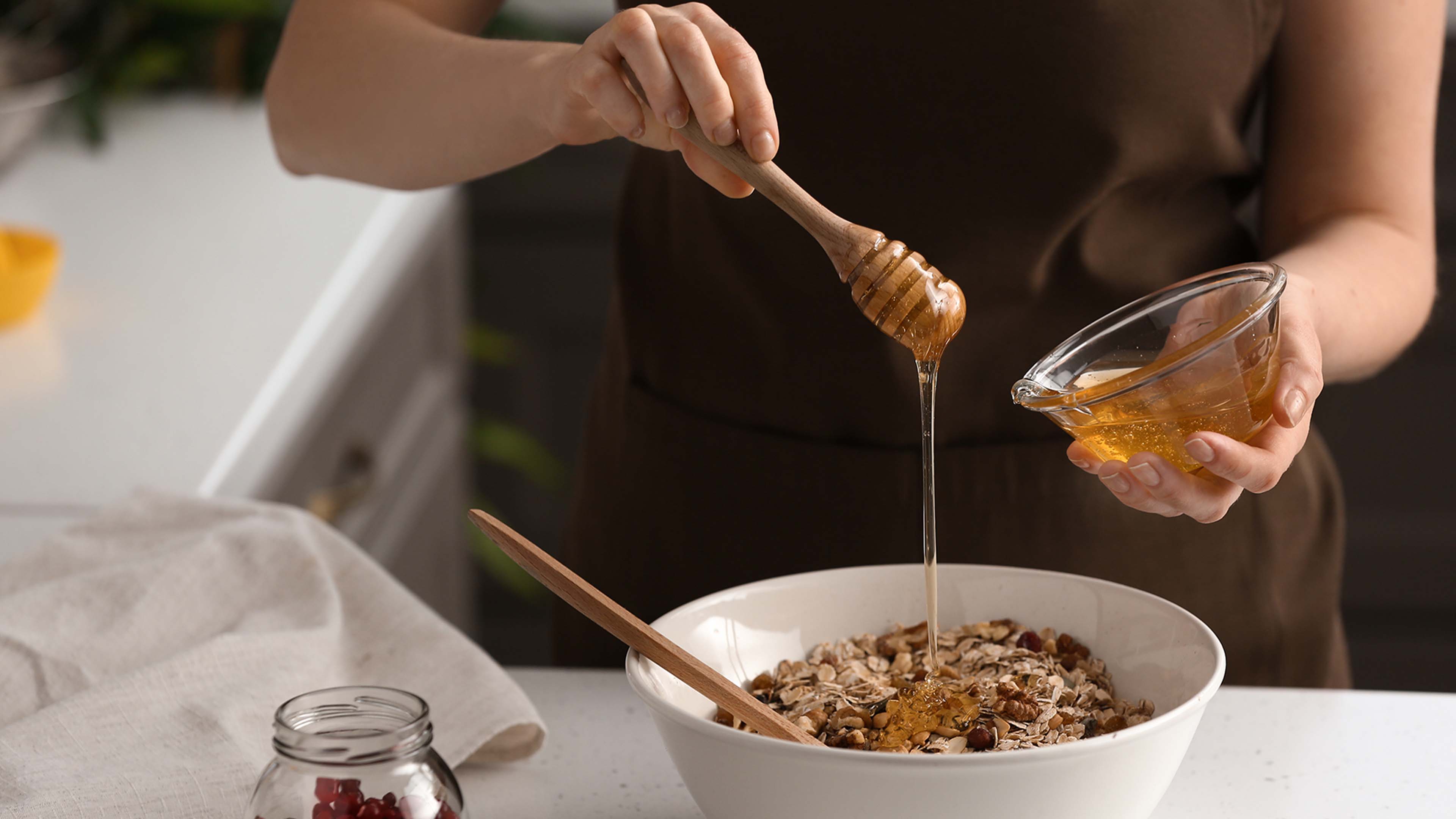 Person süßt müsli mit honig