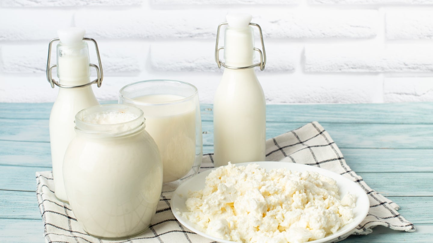 Gläser-Ziegenmilch-Hüttenkäse Gläser voll mit Ziegenmilch, daneben ein Teller mit Hüttenkäse aus Ziegenmilch