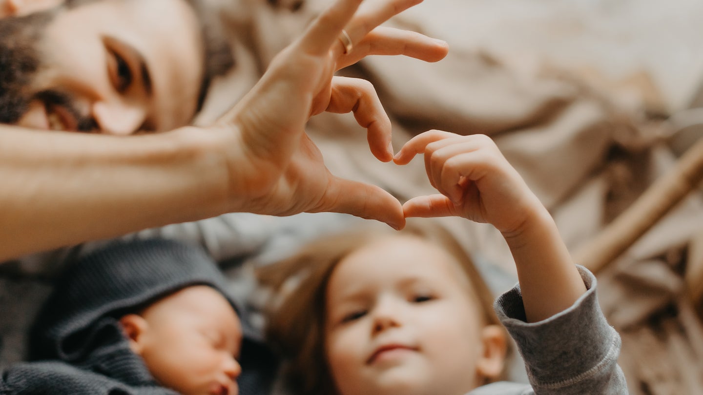 Kind formt Herz mit Hand