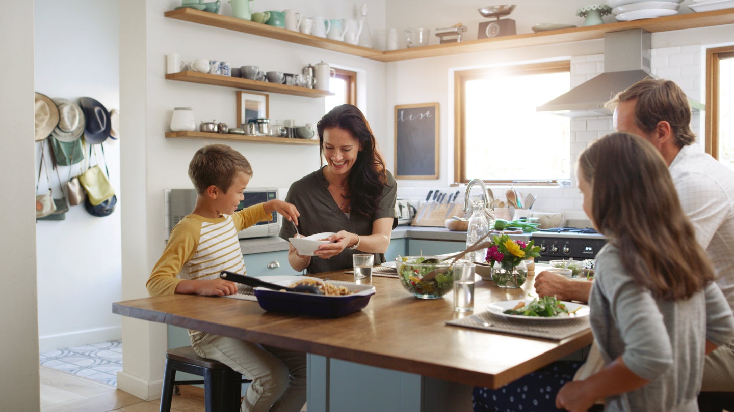 Familie sitzt gemeinsam am Tisch und isst