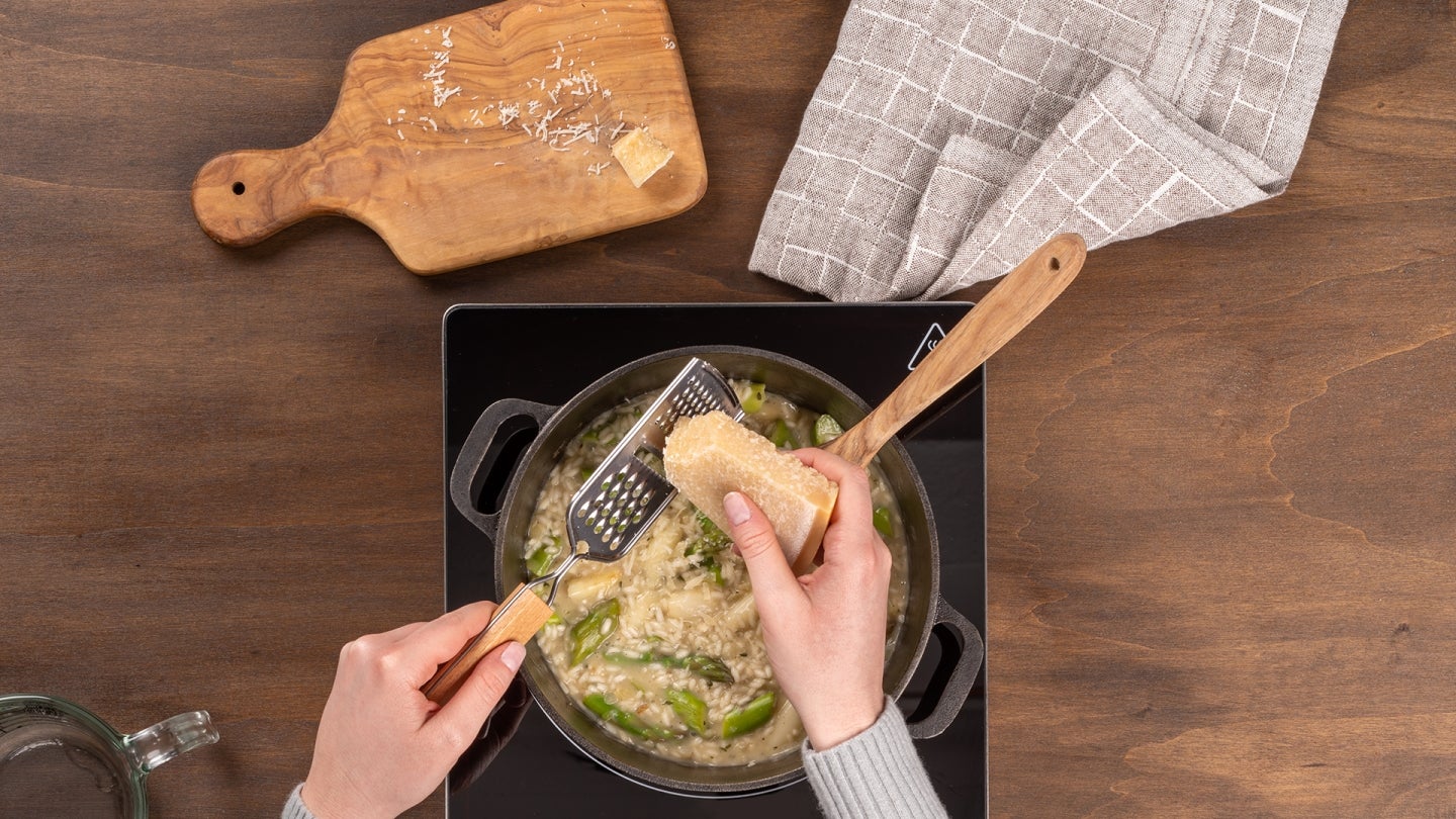 Parmesan ueber das Risotto geben