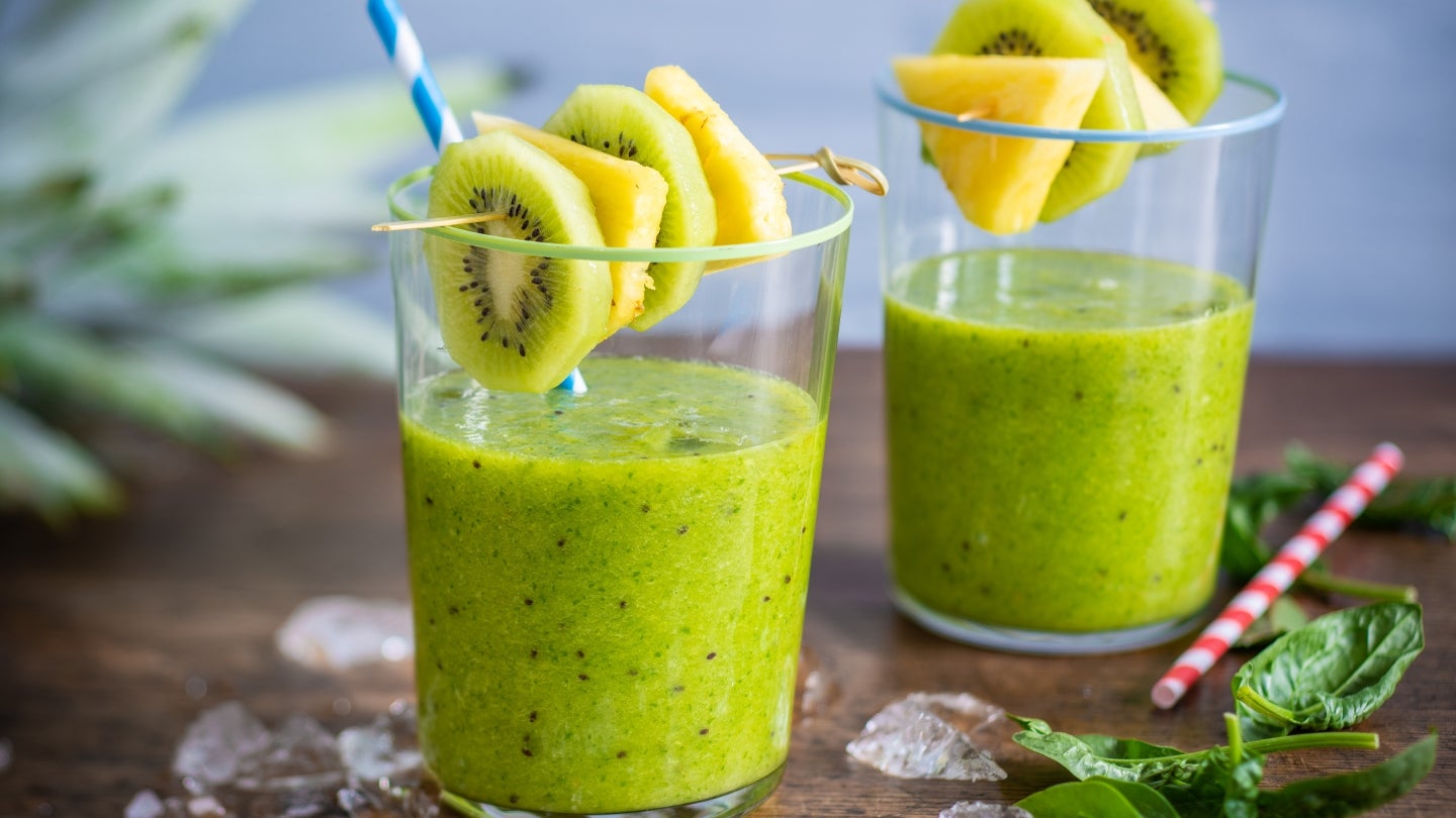 Der Grüne Smoothie mit Ananas und Kiwi-Verzierungen Der Grüne Smoothie mit Ananas und Kiwi-Verzierungen