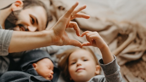 Kind und Vater formen Herz mit ihren Händen