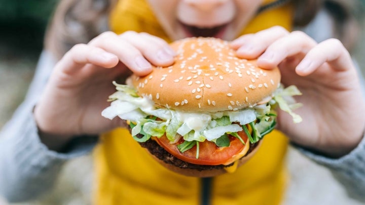Kind mit Burger in Hand