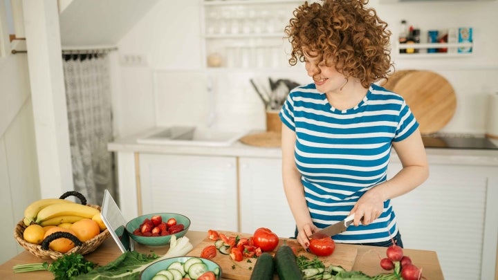 Frau schneidet Tomate