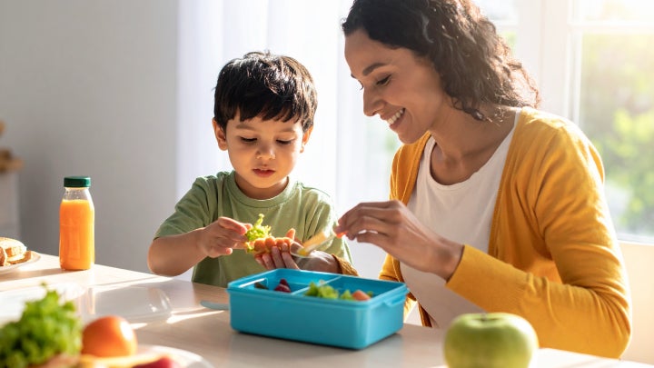Mutter und Kind bereiten gemeinsam eine Brotbox vor