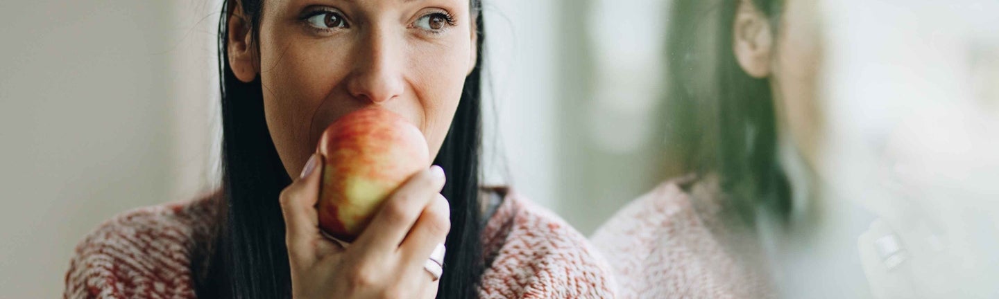 Frau beißt in Apfel