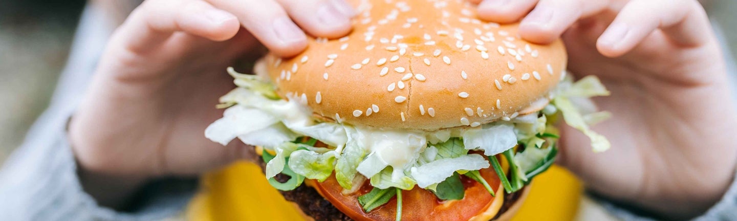 Kind mit Burger in Hand