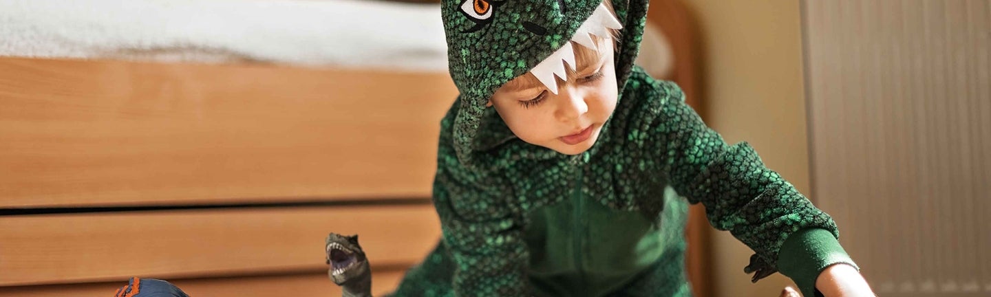 Kind in Dinokostüm