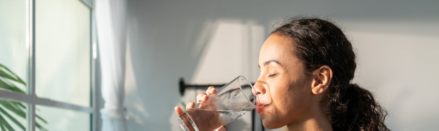 Frau trinkt Wasser in Intervallfasten Fastenperiode